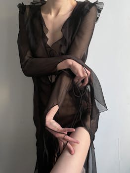 Artistic shot of a woman in sheer black lingerie, showcasing elegance and sensuality.