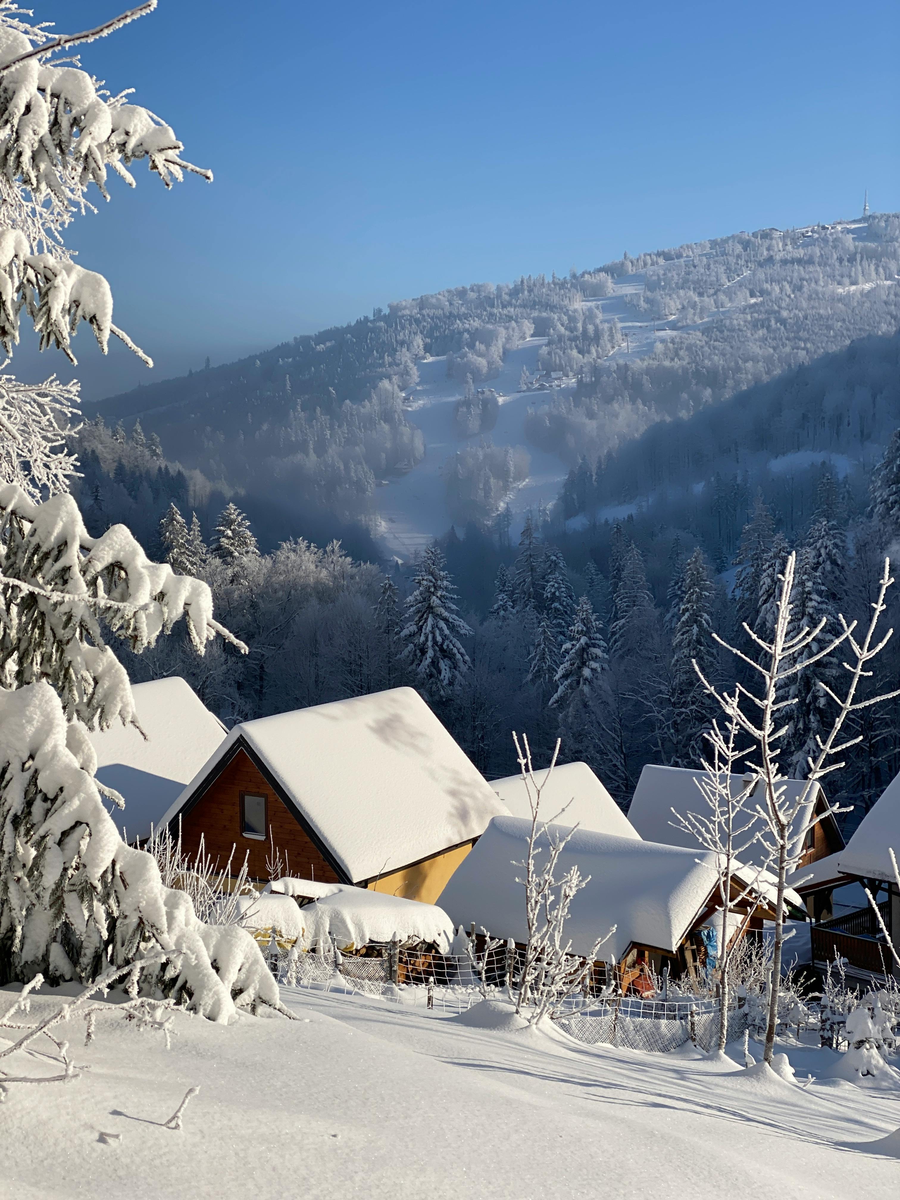 Prescription Goggle Inserts - Idyllic winter scene with snow-covered chalets and mountains on a sunny day.