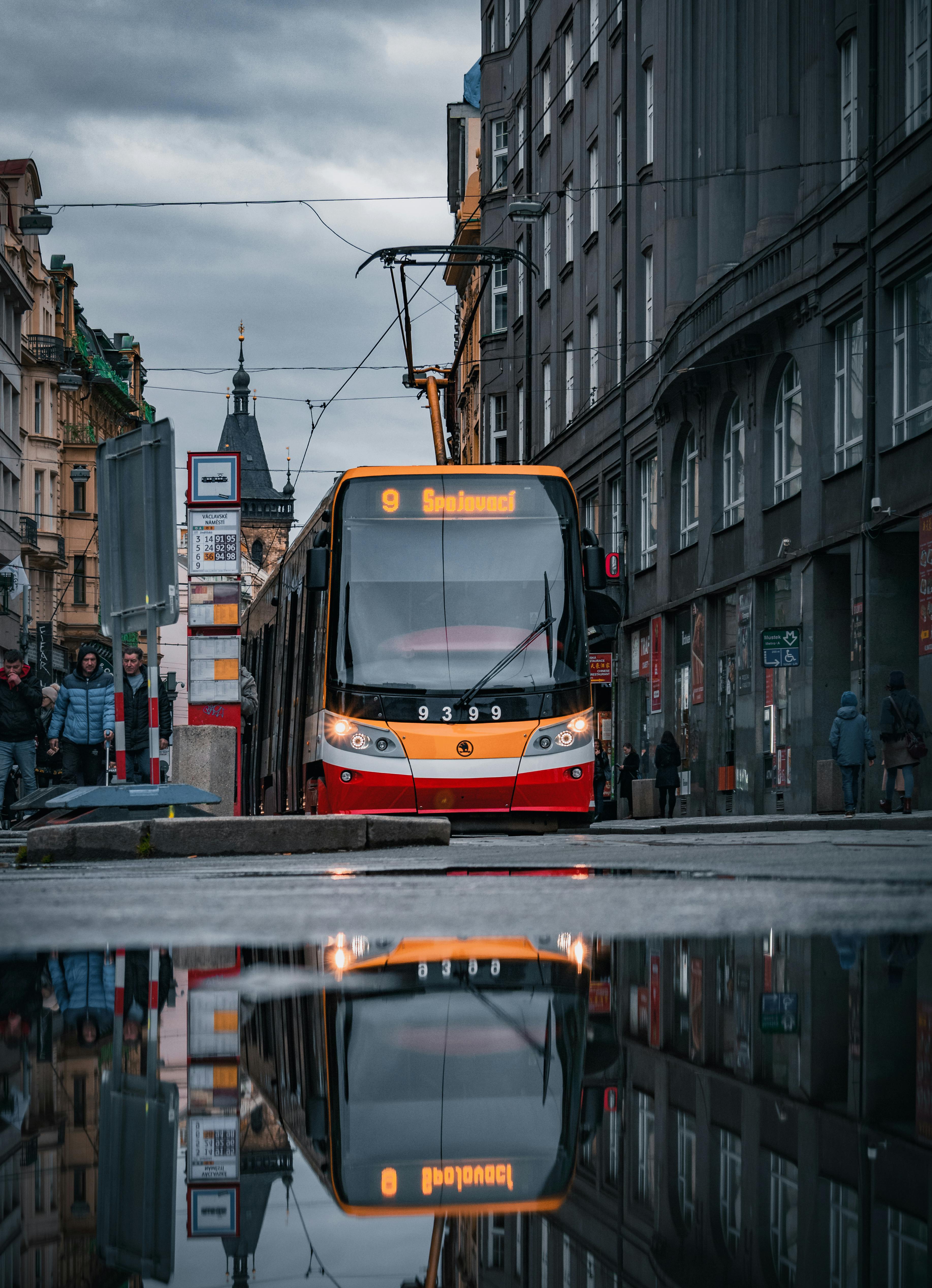 a tram is reflected in the water on a rainy day