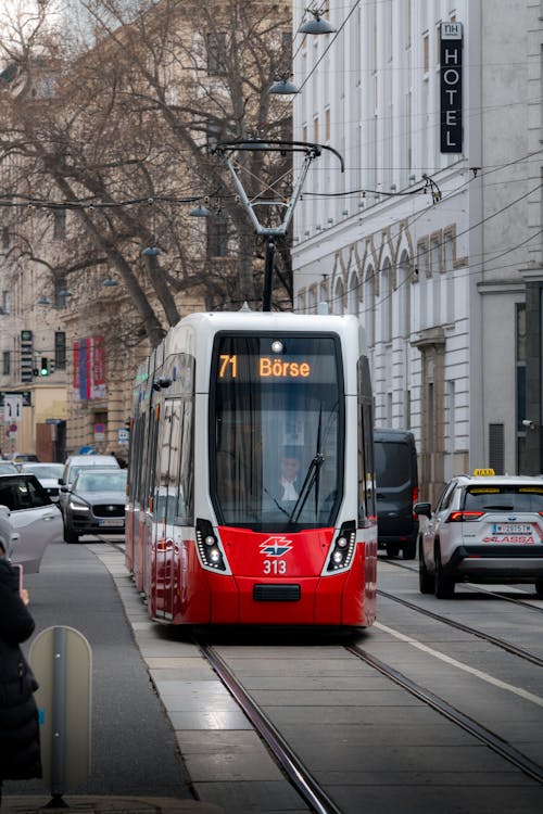 A red and white tram on a city street