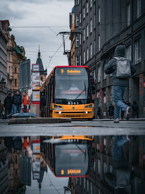 A reflection of a city bus on a puddle