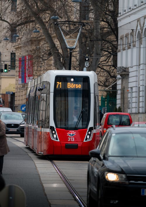 A red and white tram on a city street