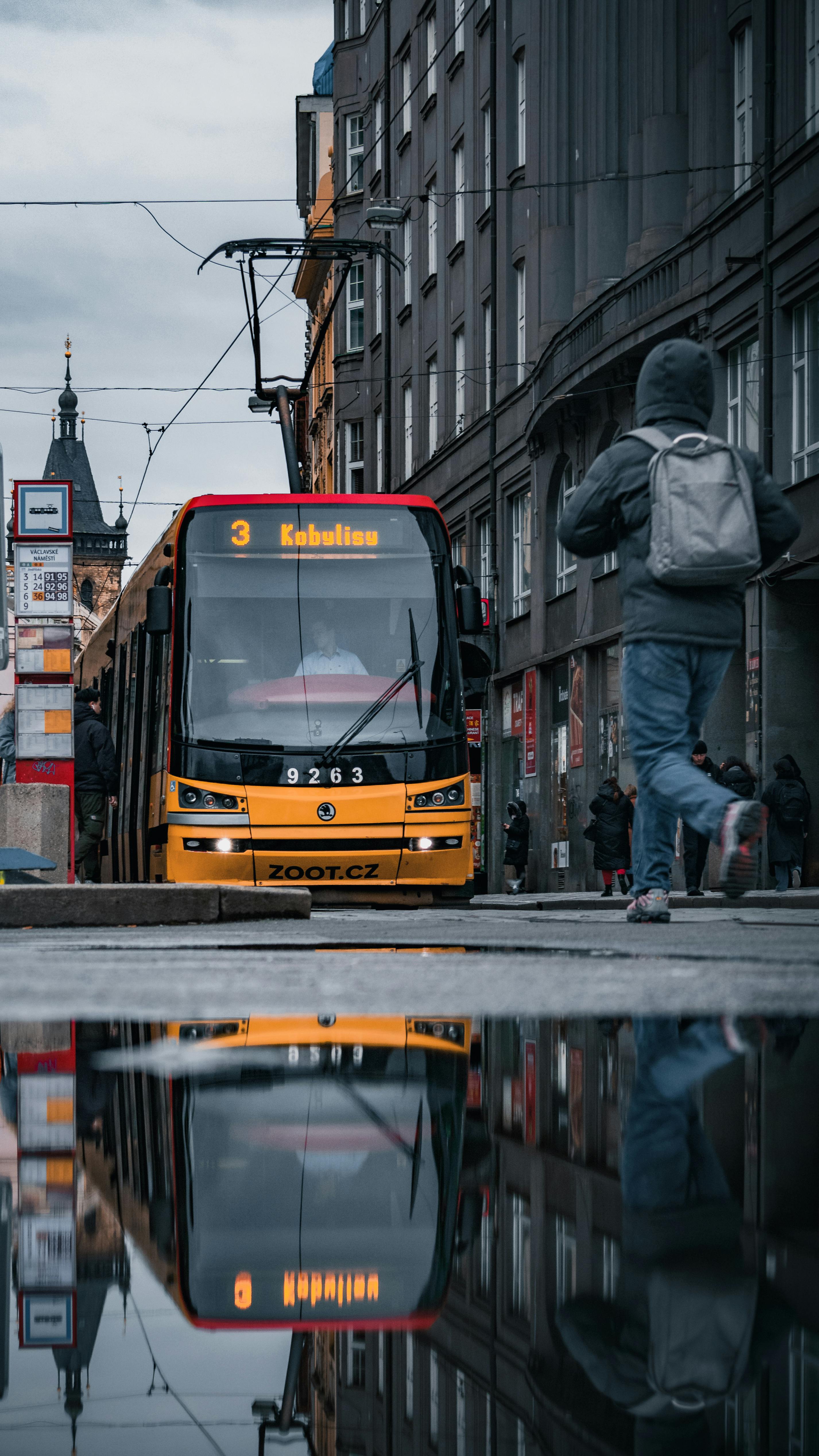 a man walking on the street next to a bus