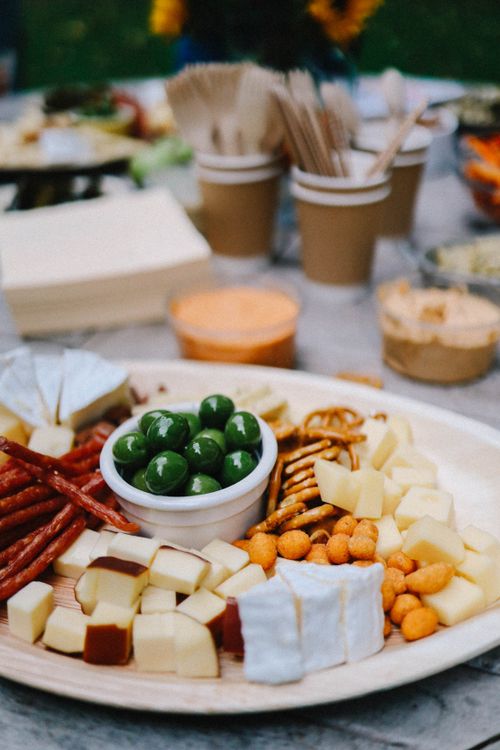 Free A vibrant cheese and snack platter on a rustic outdoor table setting. Stock Photo