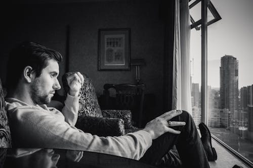 Free Grayscale Photo of Man Looking at Window Stock Photo