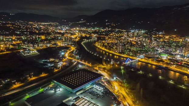 Stunning aerial view of Zenica at night, showcasing illuminated urban landscape and modern architecture.
