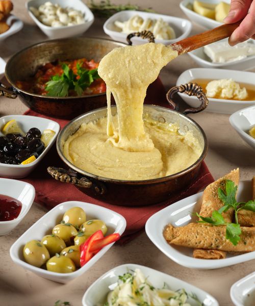 Free A vibrant spread of traditional Romanian dishes featuring mamaliga, olives, and an array of side dishes. Stock Photo