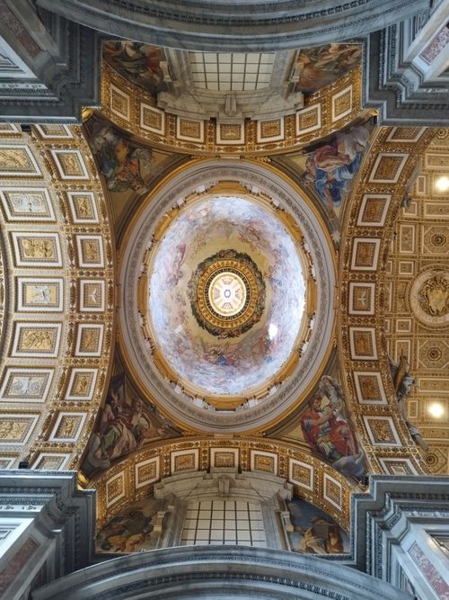 Free Intricate frescoes and gold adorn the ornate dome of St. Peter's Basilica in Vatican City. Stock Photo