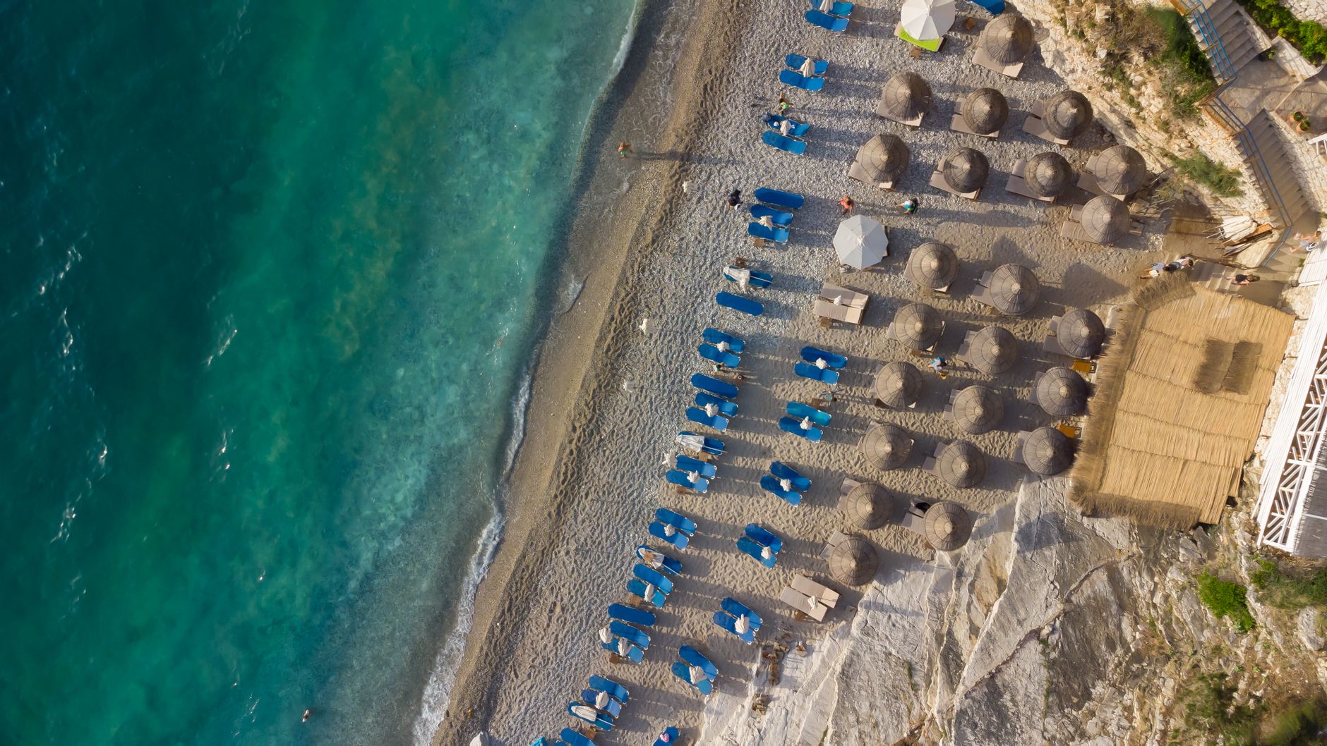 Rows of paid sunbeds and umbrellas on an organised Cypriot beach