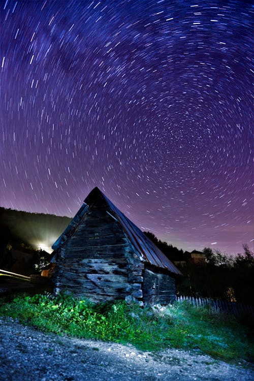 Long Exposure Photograph of a Barn and a Night Sky with Stars