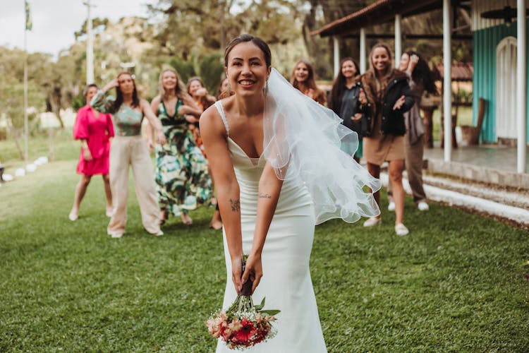 Woman In Wedding Dress Holding Flowers Bouquet