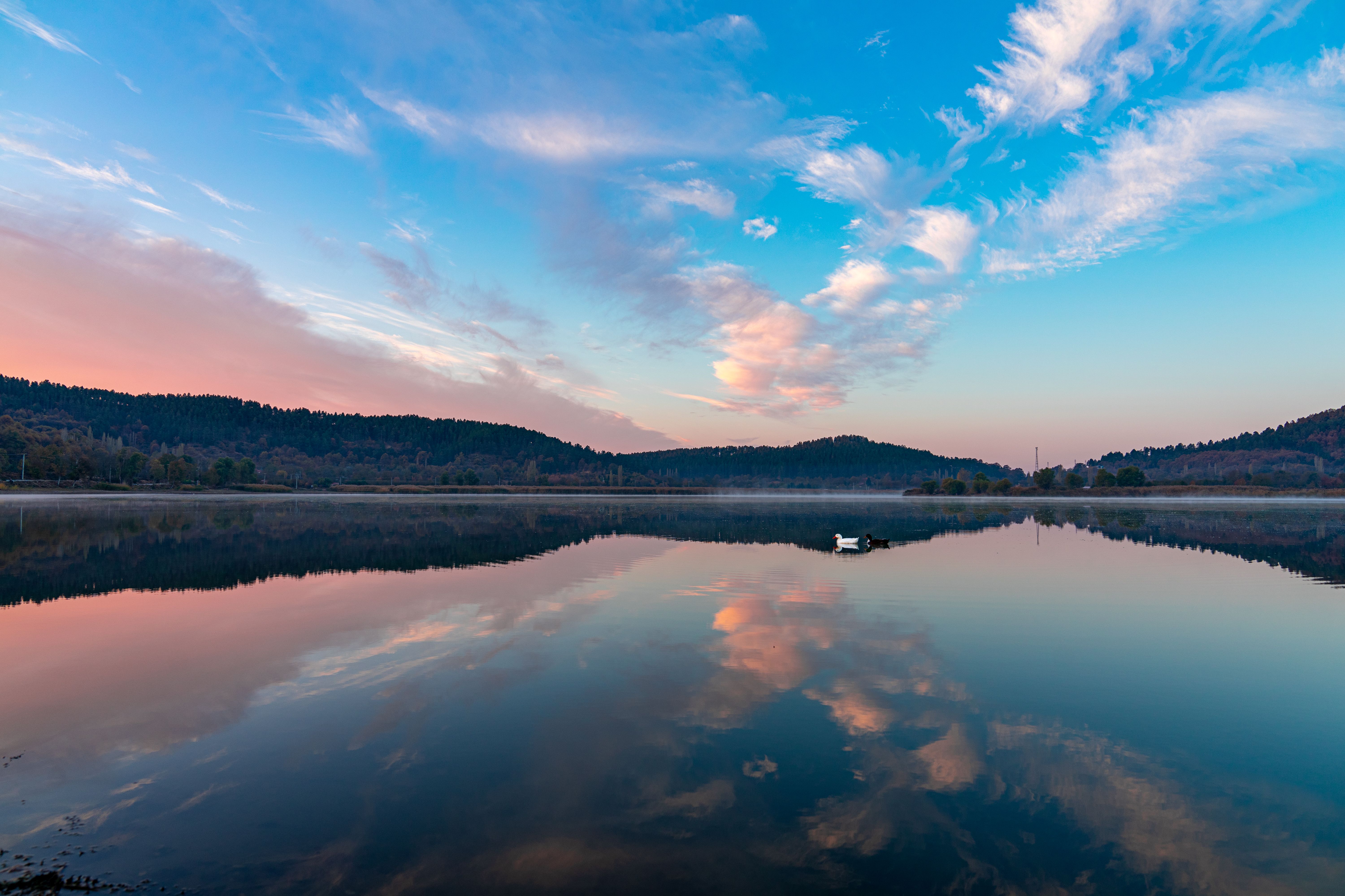 Peaceful lake reflecting colorful sky at sunset in Gölcük, İzmir, Türkiye.