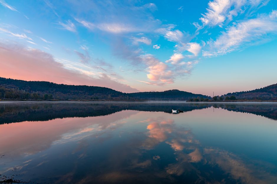 Peaceful lake reflecting colorful sky at sunset in Gölcük, İzmir, Türkiye.