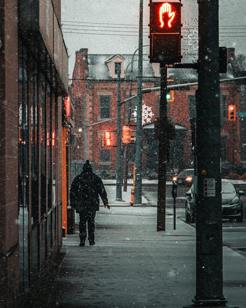 Walking Alone Through Snowy Streets of Downtown
