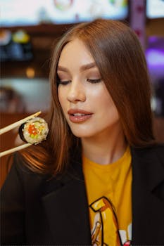 Portrait of a young woman savoring sushi in a vibrant indoor setting.