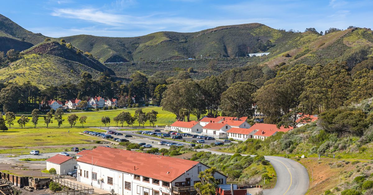Beautiful sunny valley with winding road and charming houses in the countryside.