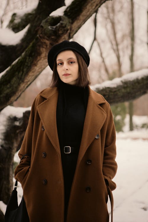 Woman Posing in Coat near Tree in Winter