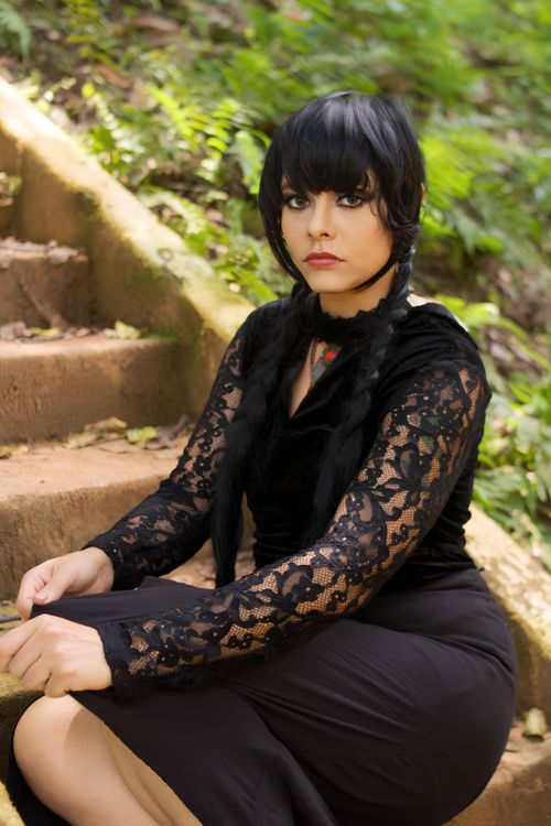Free A woman with black hair in a stylish black lace dress sits on outdoor forest steps in São Paulo, Brazil. Stock Photo