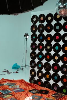 A creative studio setup featuring a wall of vinyl records with vibrant decor and lighting.
