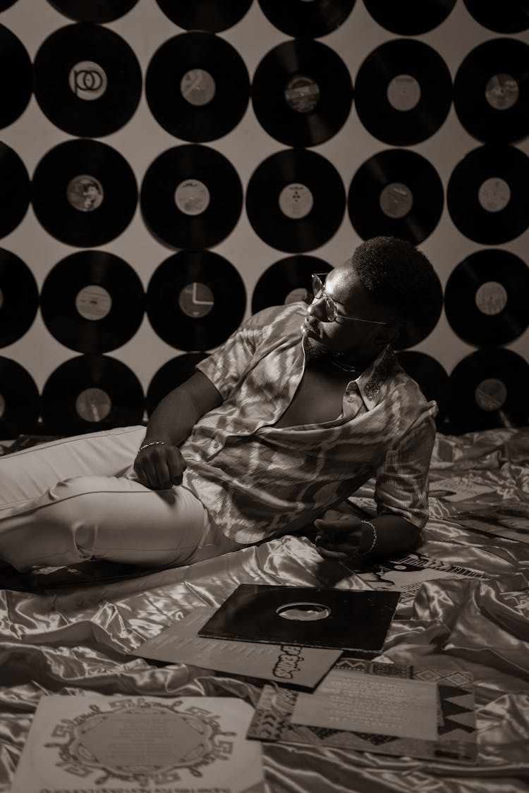 Person Lying On Ground Surrounded By Vinyl Records