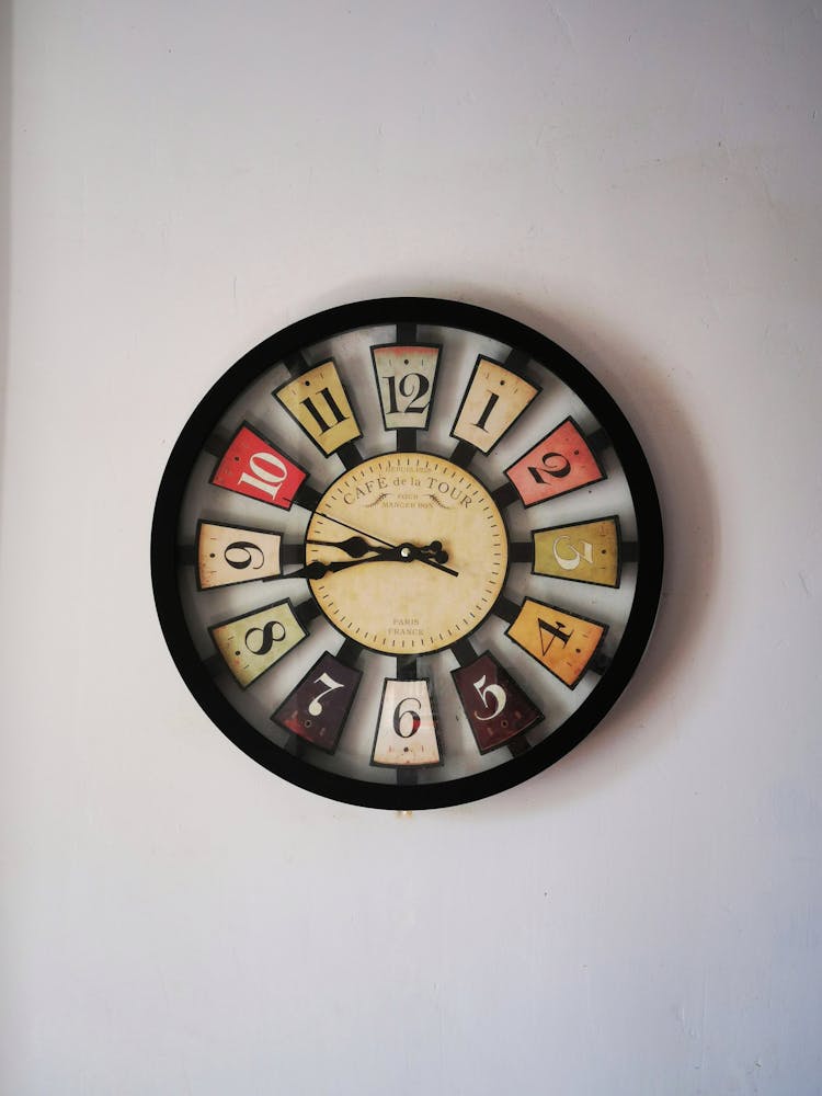 A Wooden Clock Hanging On A Wall 