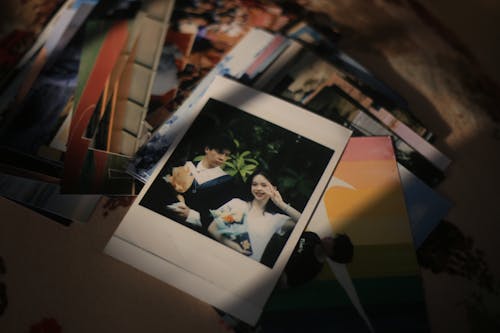 A Polaroid of Two Young People among other Photographs