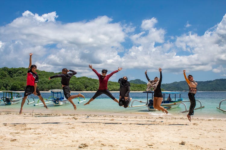 Group Of Friends Jumping On A Beach 