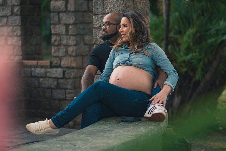 Pregnant woman and partner relaxing outside, showcasing love and anticipation.