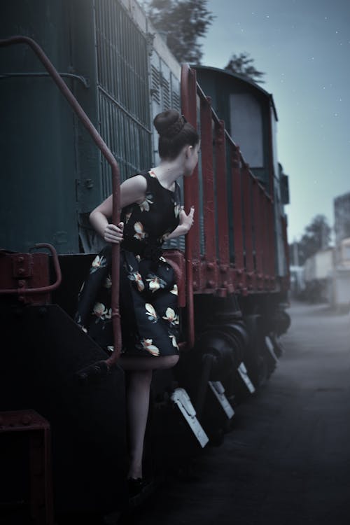 무료 기차 옆에 서있는 검은 민소매 드레스 여자 스톡 사진
