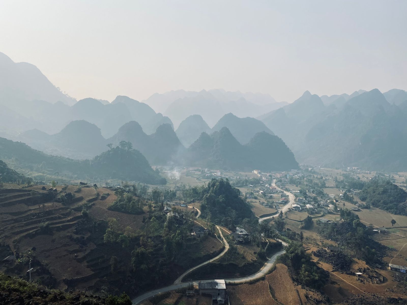 Foggy Ha Giang mountain landscape with layered valleys and village scenery
