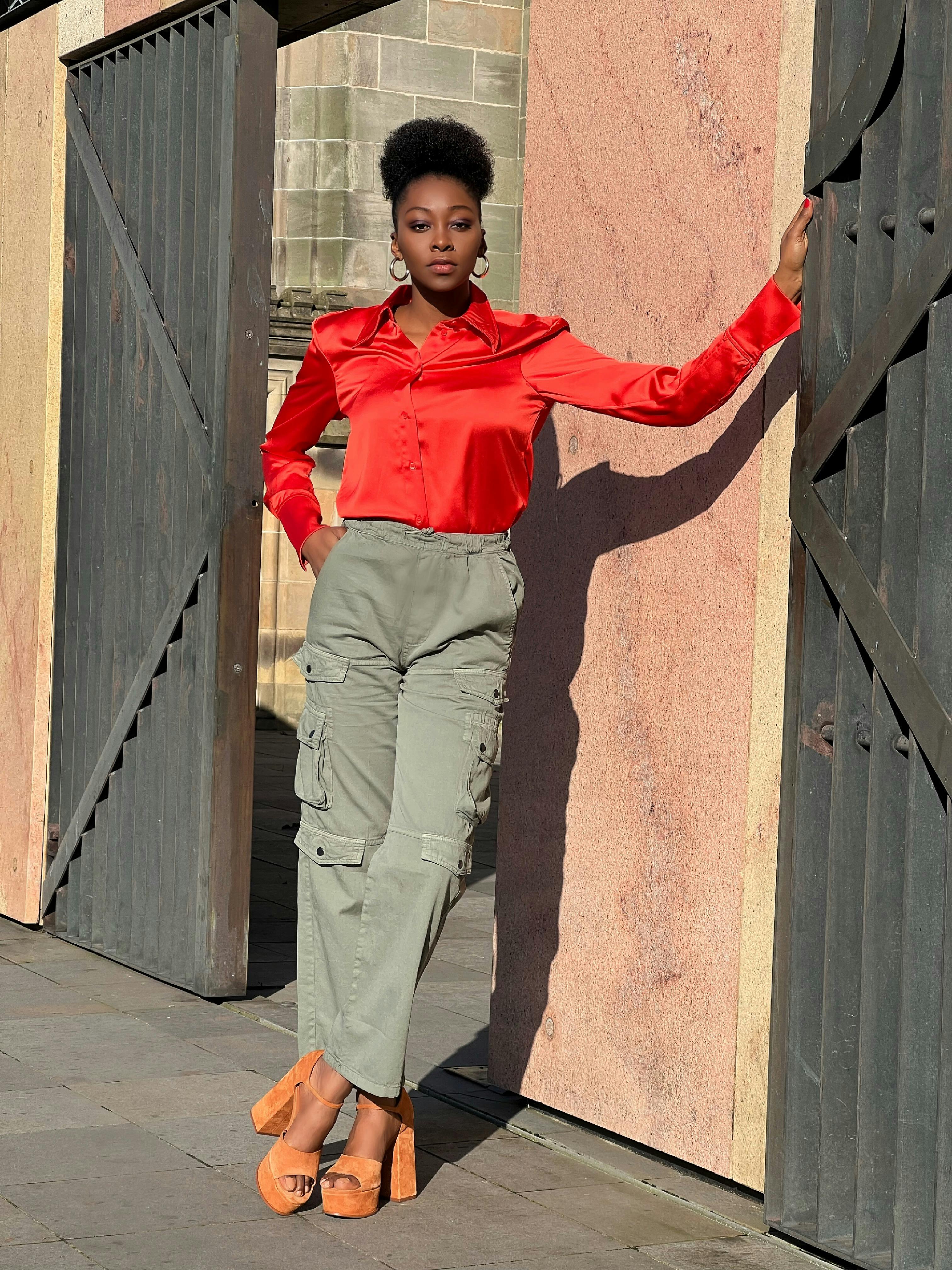free photo of african woman posing in red shirt on a street