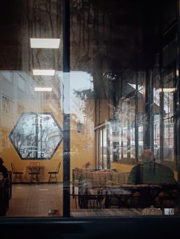An intimate indoor cafe view with reflective glass, showcasing a serene setting and modern design.