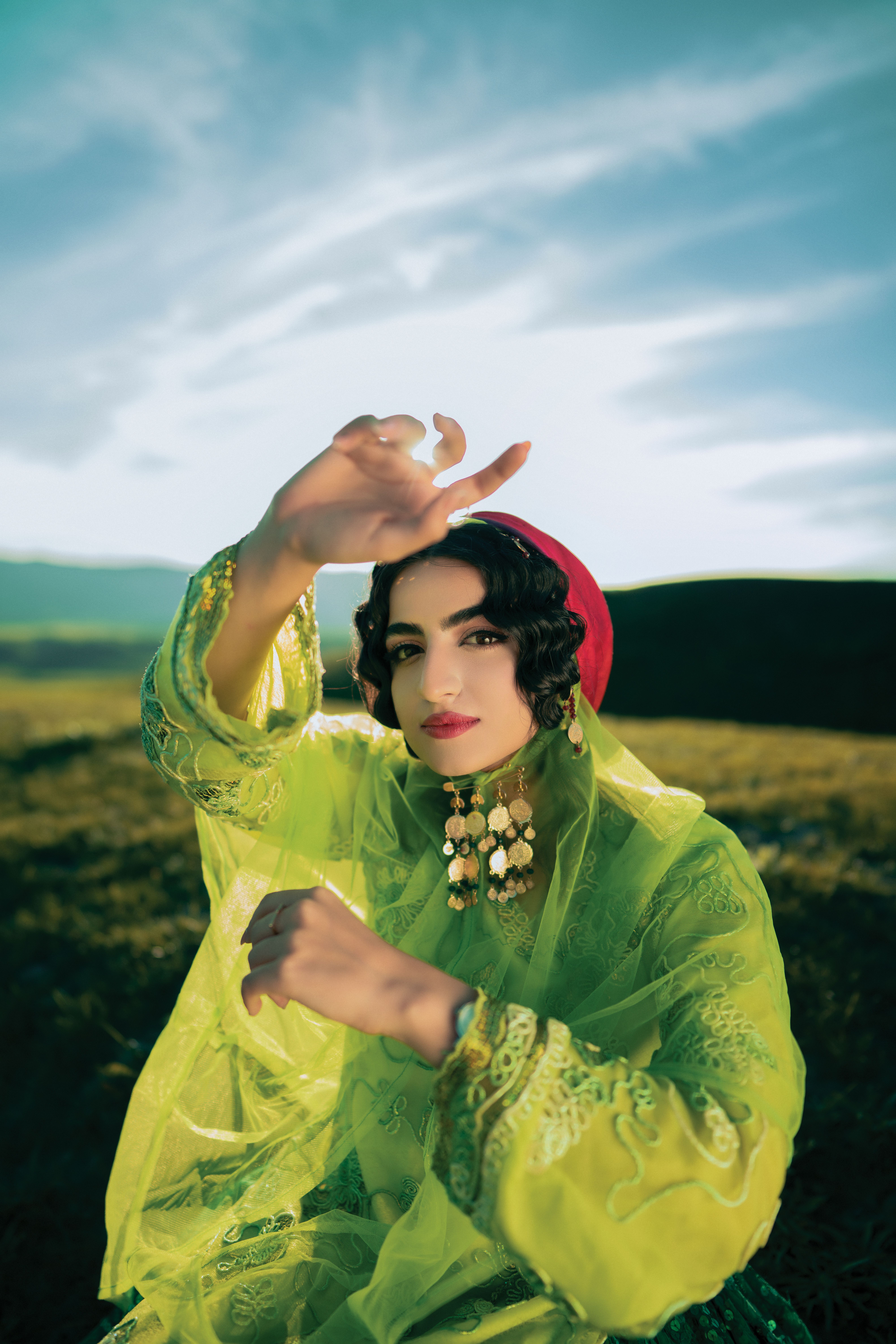 Artistic portrait of a woman in green fashion with sunny backdrop.