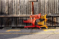 阳光明媚的日子里，质朴的木栅栏旁停靠着红色和黄色的购物车