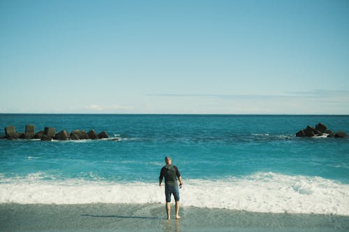 Back View of Man Standing on Sea Shore