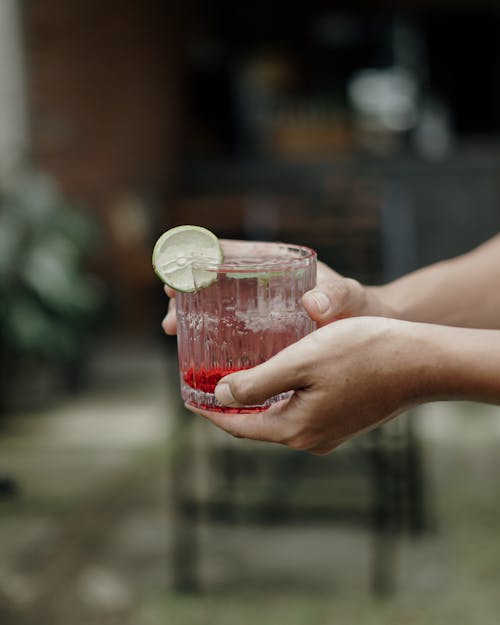 Hands Holding Drink with Lime