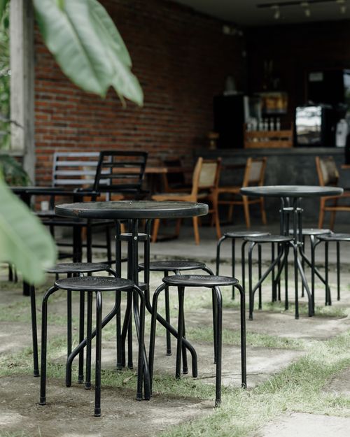 Free Charming outdoor bistro with metal tables and chairs, perfect for a serene café experience. Stock Photo