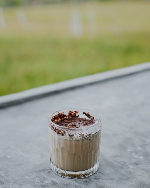 Free A creamy chocolate coffee dessert in a glass, with a rustic outdoor background. Stock Photo