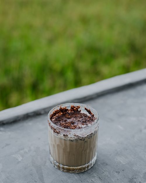 Free Close-up of a chocolate dessert in a glass with a rich topping, outdoors. Stock Photo