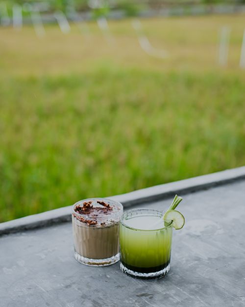 Free Two drinks on an outdoor table: a green cocktail with lime and a chocolate coffee. Stock Photo