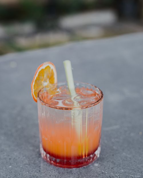 Free Vibrant citrus cocktail with orange garnish, perfect for summer refreshments. Stock Photo