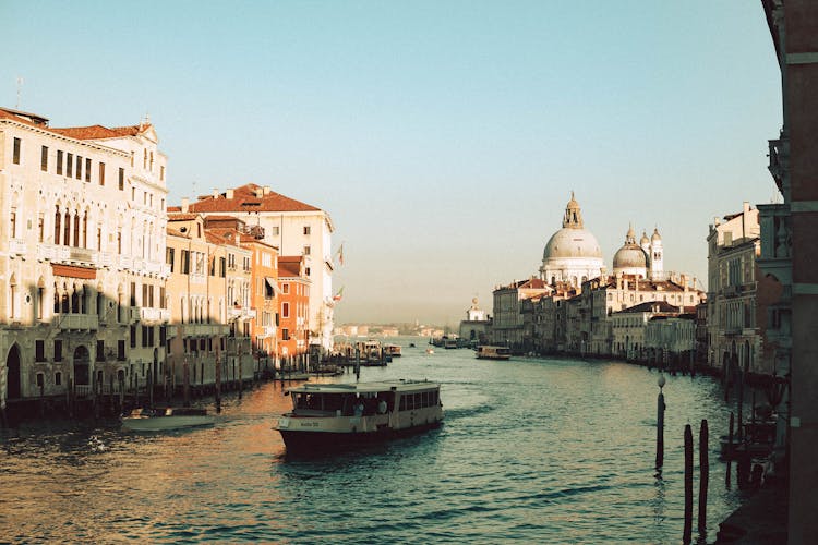 View Of A Boat On Canal Grande And The Santa Maria Della Salute Church In The Background, Venice, Italy 