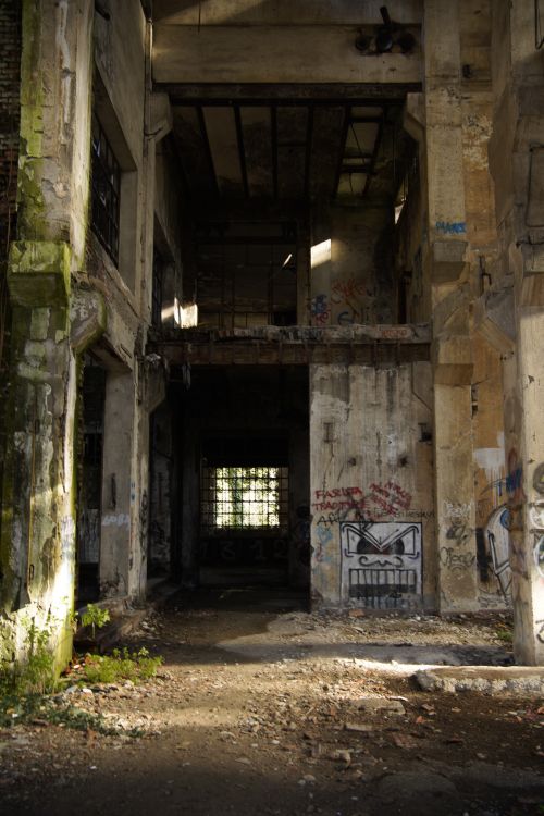 Free Interior of an abandoned factory with graffiti-covered walls and debris. Stock Photo