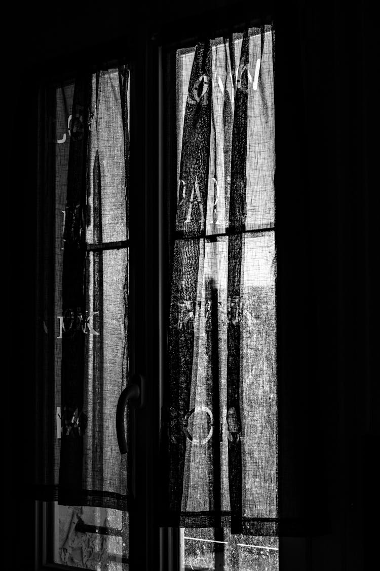 Black And White Photo Of A Curtain In A Window 