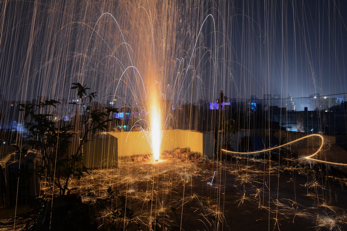 Steel Wool Photography of Plant on Roof Top during Nighttime