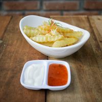 Bowl of crinkle-cut fries with dips — photo by Arya Bajra on Pexels