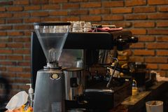 Inviting café interior with espresso machine and grinder on a wooden counter.