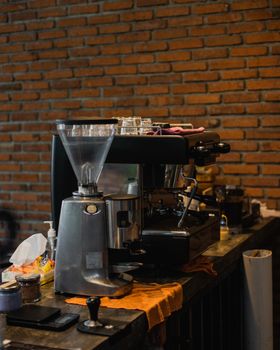 Inviting café interior with espresso machine and grinder on a wooden counter.