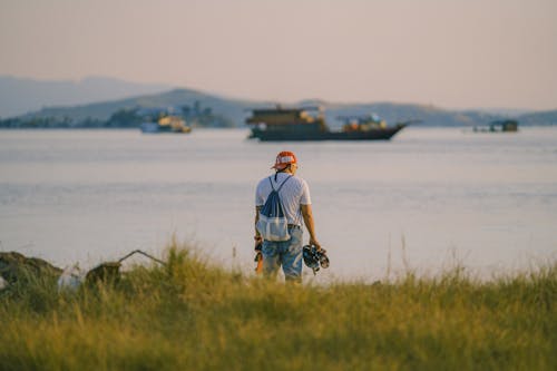 Man Standing with Bag by Water