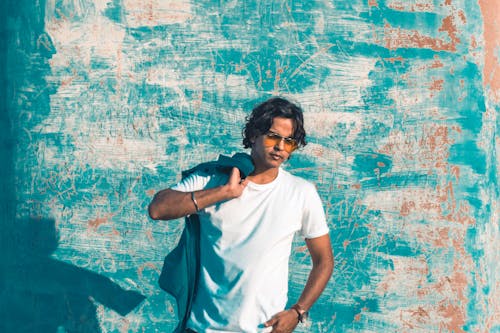 Man Standing Near Blue Painted Wall